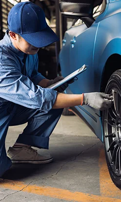 Maintenance male checking tire service via insurance system at garage